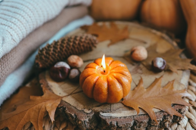 Burning candle in the shape of a pumpkin autumn aesthetic mood