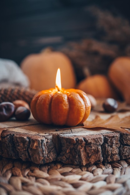 Burning candle in the shape of a pumpkin autumn aesthetic mood