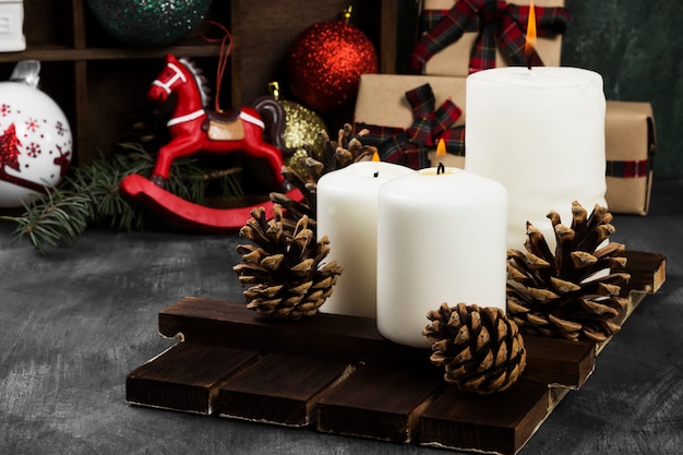 Burning candles and Christmas attributes on a dark surface