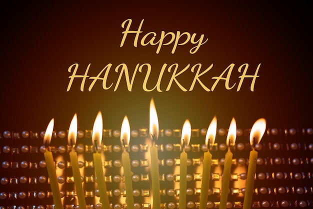 Burning candles on a dark background and text Happy Hanukkah