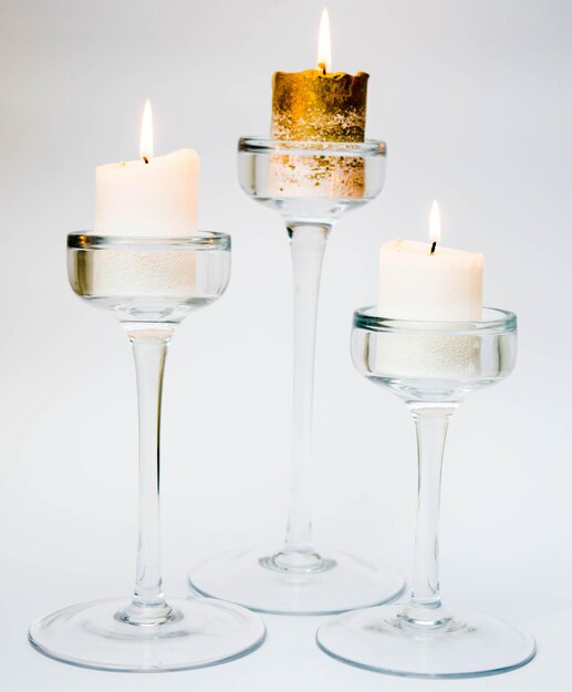 Photo burning candles in a glass candlestick