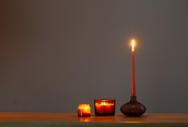 burning candles in glass candlesticks on dark background