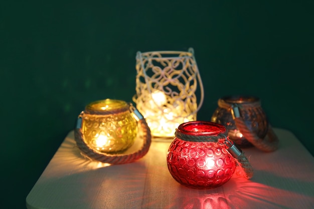 Burning candles in glass holders on table