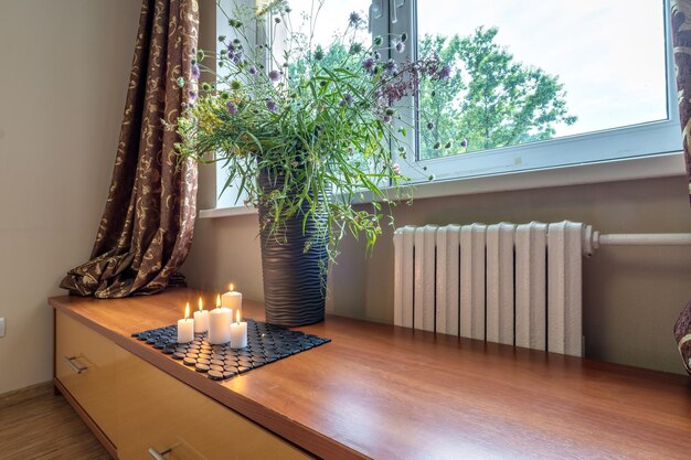 Burning candles on a table with flowers with glasses or fruits intimate romantic atmosphere