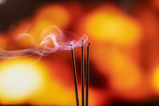 Burning Incense Sticks with smoke, joss sticks burning at a vintage Buddhist temple