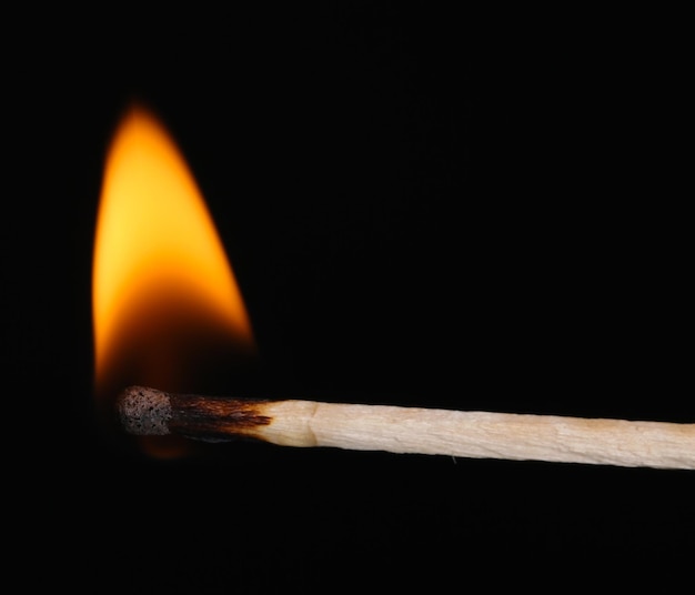 Photo burning match isolated on black