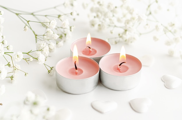 Burning perfumed candles decorated with flowers.