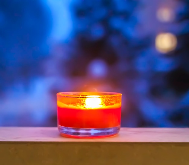 Burning red candle on winter background