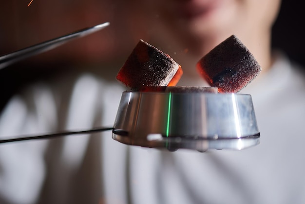 Burning red coals for hookah during preparation