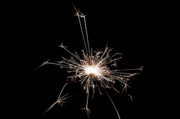 Burning sparkler isolated on black background Fireworks theme Light effect and texture