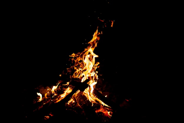 Burning woods with firesparks, flame and smoke at night.