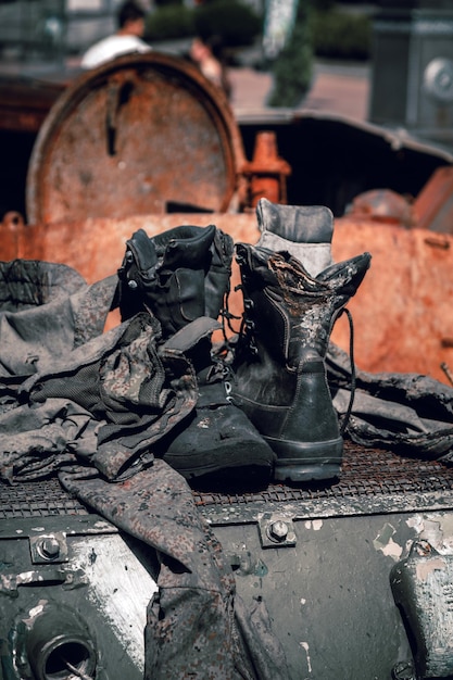 Burnt boots and pieces of clothing of a Russian soldier on padded armored vehicle in war in Ukraine