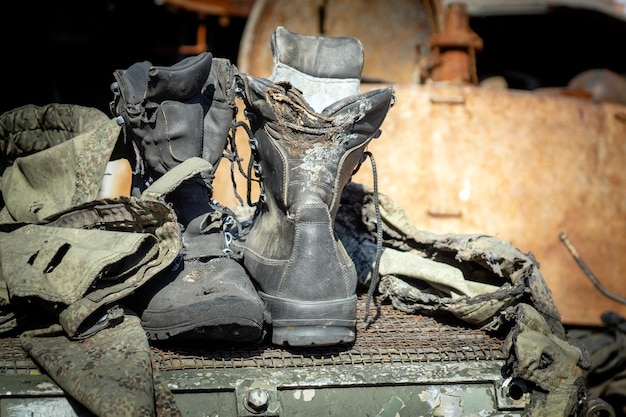 Burnt boots and pieces of clothing of a Russian soldier on padded armored vehicle in war in Ukraine