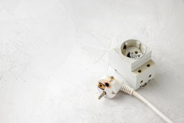 Burnt plug with European type F socket due to a short circuit in the electrical network