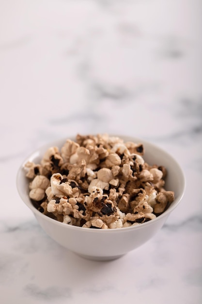 Burnt popcorn in the small white bowl on ceramic