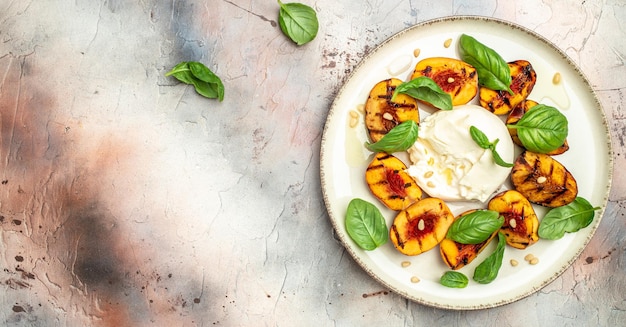 Burrata cheese and grilled peaches with rose wine top view place for text