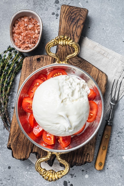 Burrata Italian cheese made from cream and milk of buffalo or cow Gray background Top view