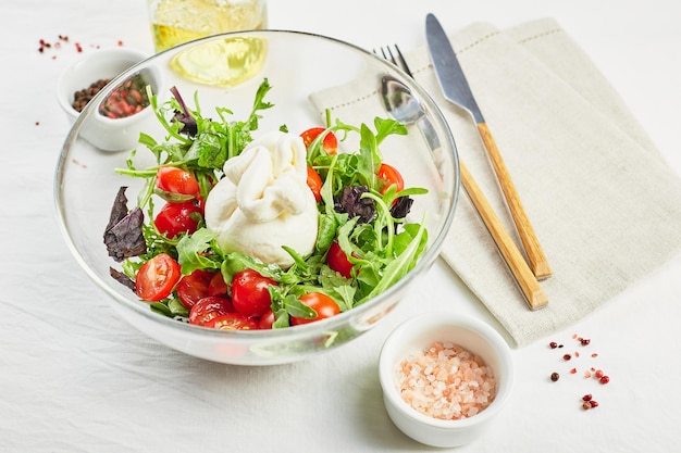 Burrata Italian fresh cheese made from cream and buffalo or cow milk with tomato arugula and red basil salad