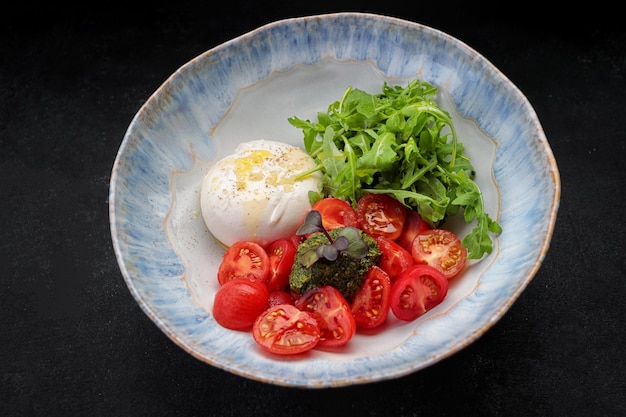 Burrata with arugula cherry tomatoes and pesto sauce