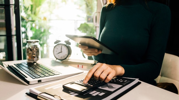 Business accounting concept Business man using calculator with computer laptop budget and loan paper in office