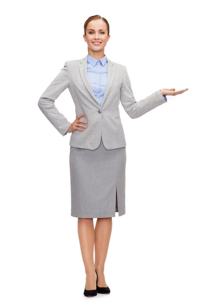 business and advertisement concept - smiling businesswoman showing something on palm of her hand