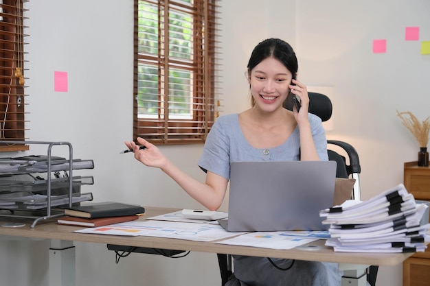 Business asian woman using smartphone for do math finance on wooden desk in office tax accounting financial concept