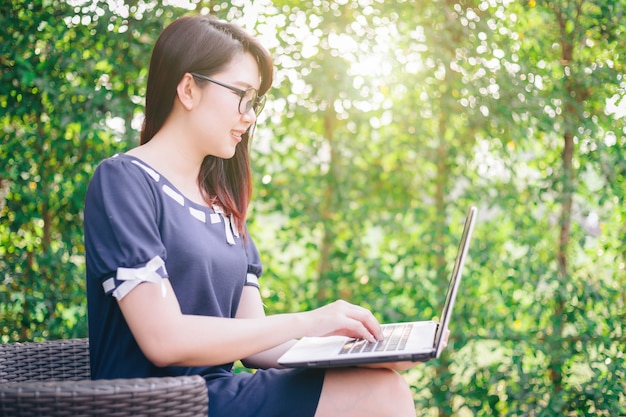 Business Asian woman working with laptop computer on office outdoor.