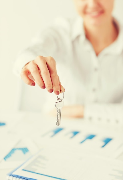 Photo business, banking, real estate concept - woman hand holding house keys