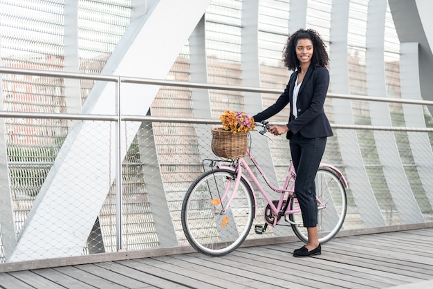 Business black woman with vintage bicycle in a bridge