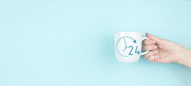 Business button 24 hours service. Girl hand hold morning coffee cup with sign 24 hour Icon on blue background. Full time service concept