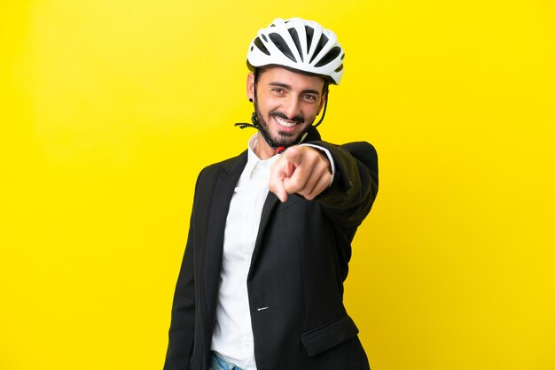 Business caucasian man with a bike helmet isolated on yellow background points finger at you with a confident expression