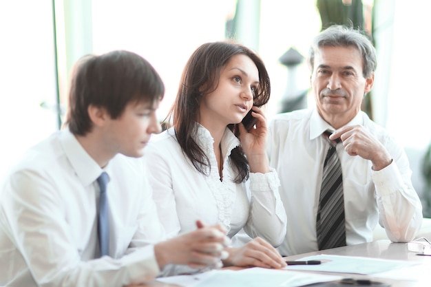 Business colleagues analyzing financial statistics sitting at a Desk in the office.