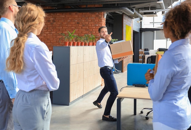 Photo business colleagues escorting the dismissed employee from office showing fuck