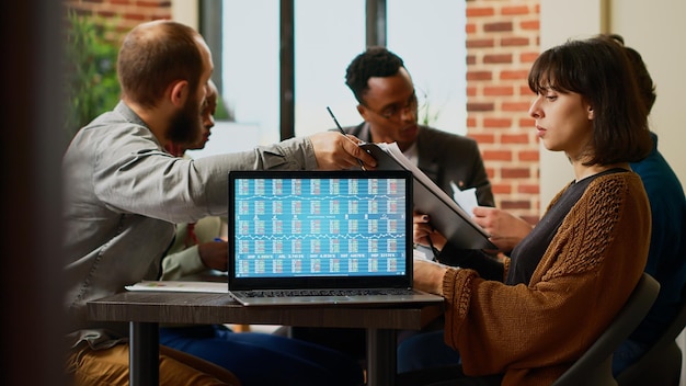 Business colleagues wokring with real time stock market exchange statistics on laptop in startup office. Using capital investment money and profit trade rate, forex index and analysis. Close up.