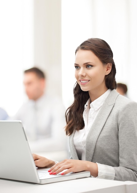 business and communication concept - businesswoman with laptop computer at work