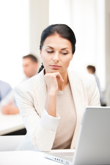 business and communication concept - businesswoman with laptop computer at work