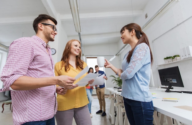 business, communication, startup and people concept - happy multiracial creative team or students on coffee break talking at office