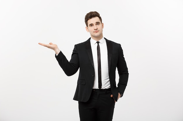 Business Concept: Attractive handsome business man shows hand on side. Copy space on white background