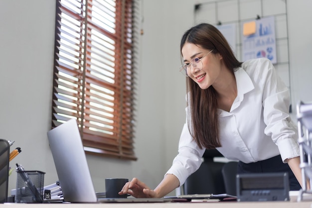 Business concept Businesswoman is typing to searching data and reading business report on laptop