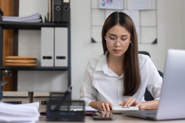 Business concept Businesswoman reading document and use calculator to calculate investment budget