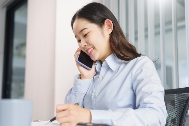 Business concept Businesswoman talking with partners on phone to checking information on document