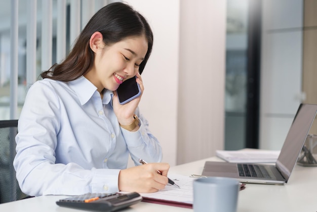 Business concept Businesswoman talking with partners on phone to checking information on document