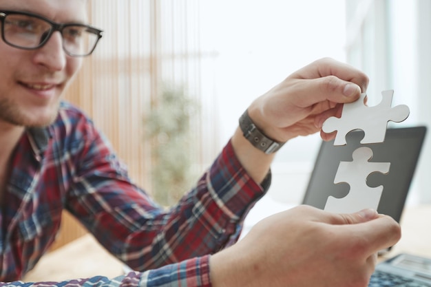 Business concept Hand holding two pieces of a puzzle