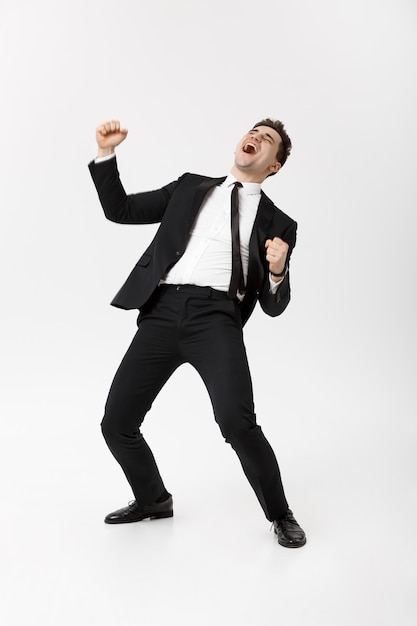 Business Concept - Handsome cheerful businessman showing hands in air over gray background.