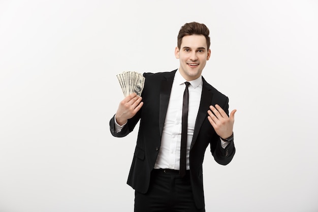 Business Concept: Portrait handsome businessman suit holding fan of dollar cash isolated over white gray background.