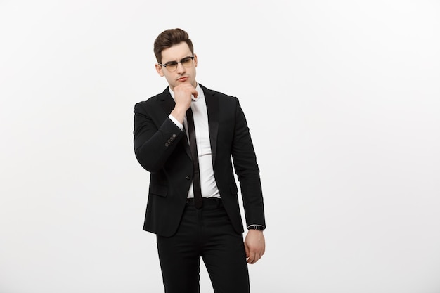 Business Concept: Portrait of Thoughtful handsome Businessman wearing smart suit in thinking gesture isolated over white background.