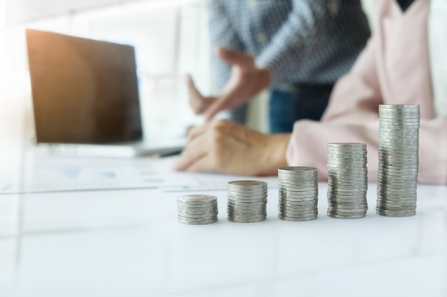 Business concept. Rows of coins for finance and banking concept with business man and woman. A metaphor of international financial consulting.