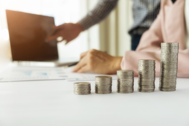 Business concept. Rows of coins for finance and banking concept with business man and woman. A metaphor of international financial consulting.