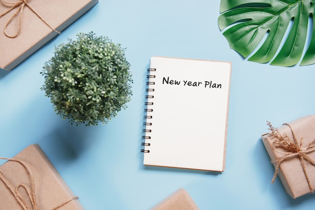 Business concept. Top view blank white notebook writing New Year Plan