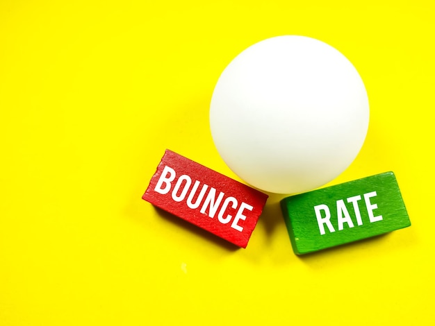 Photo business concepttext bounce rate writing on colored wooden block with ping pong ball on a yellow background